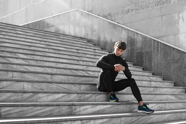 Hombre en ropa deportiva en las escaleras al aire libre