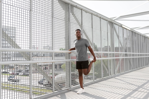 Foto gratuita hombre en ropa deportiva haciendo ejercicio al aire libre