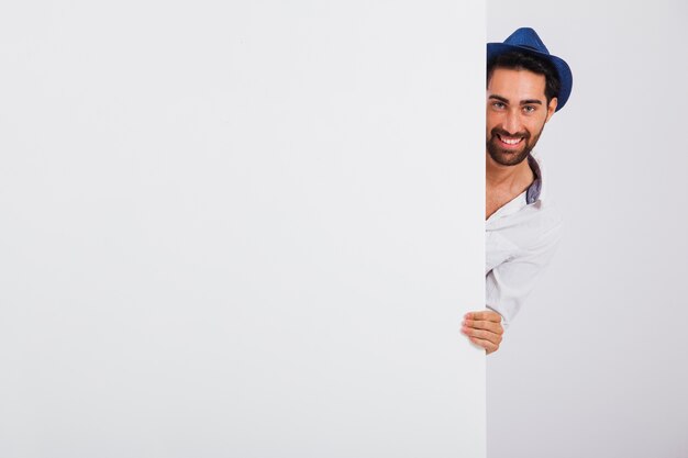 Hombre en ropa de verano detrás de puerta