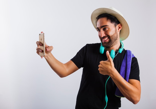 Hombre en ropa de verano haciendo un selfie y el signo de ok vista cercana