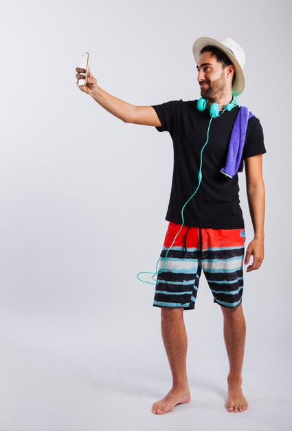 Hombre en ropa de verano haciendo un selfie
