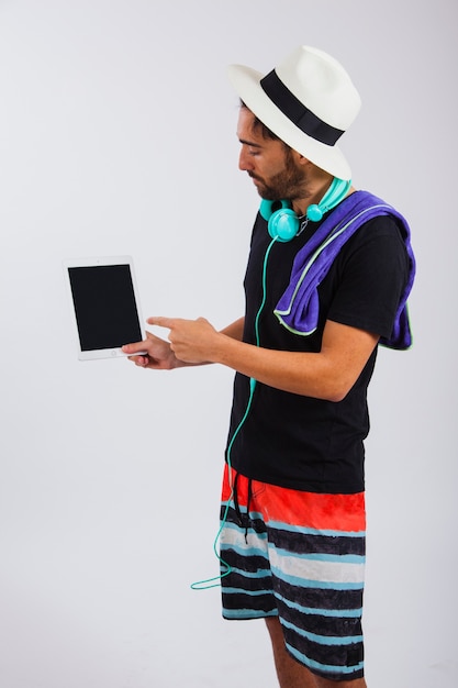Hombre en ropa de verano presentando tablet