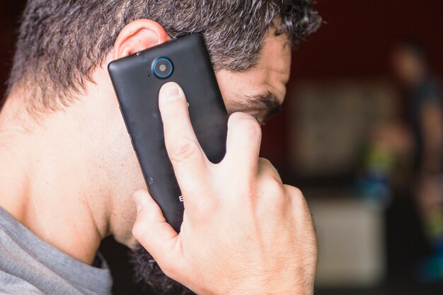 Hombre sin rostro hablando por teléfono