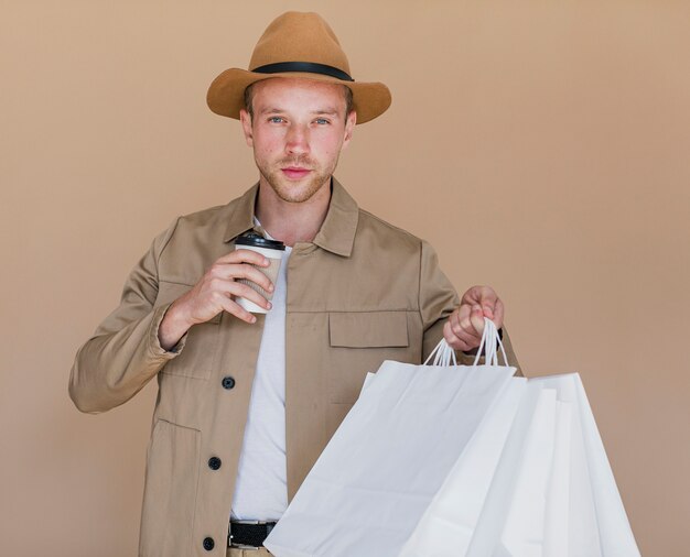 Hombre rubio con bolsas de compras mirando a la cámara