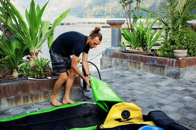 El hombre saca una tabla de sup.