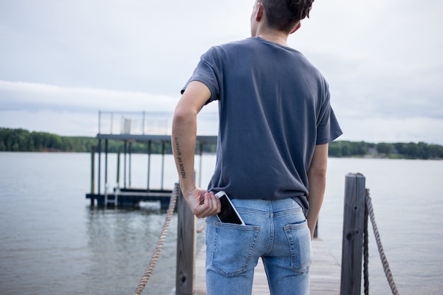 Hombre sacando su teléfono inteligente del bolsillo trasero.