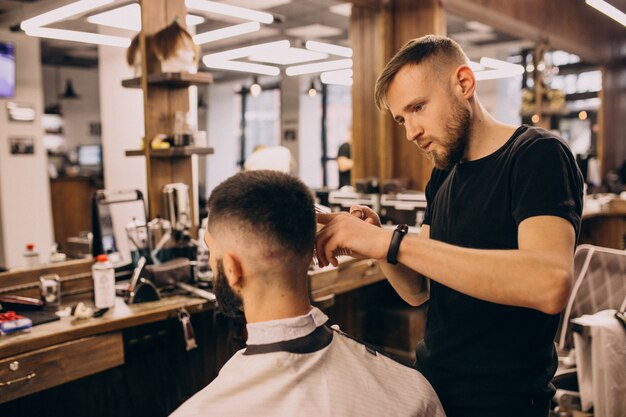 Hombre en un salón de peluquería haciendo corte de pelo y barba