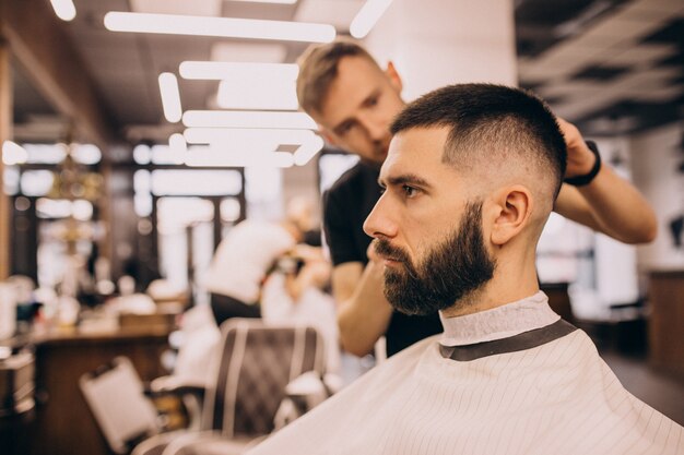 Hombre en un salón de peluquería haciendo corte de pelo y barba