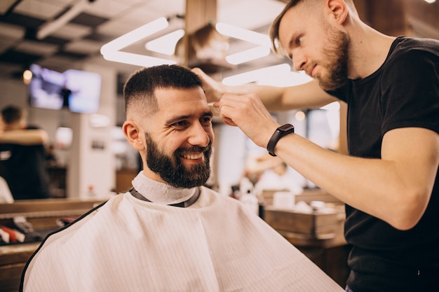 Foto gratuita hombre en un salón de peluquería haciendo corte de pelo y barba