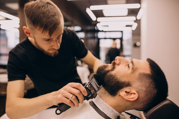 Hombre en un salón de peluquería haciendo corte de pelo y barba