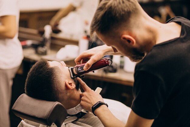 Hombre en un salón de peluquería haciendo corte de pelo y barba