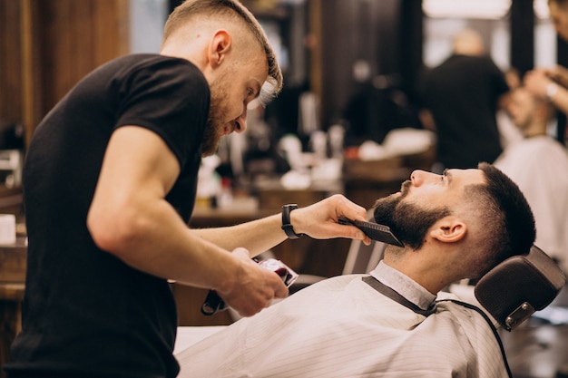 Hombre en un salón de peluquería haciendo corte de pelo y barba