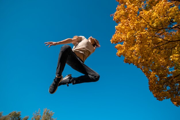 Hombre saltando al aire libre vista inferior