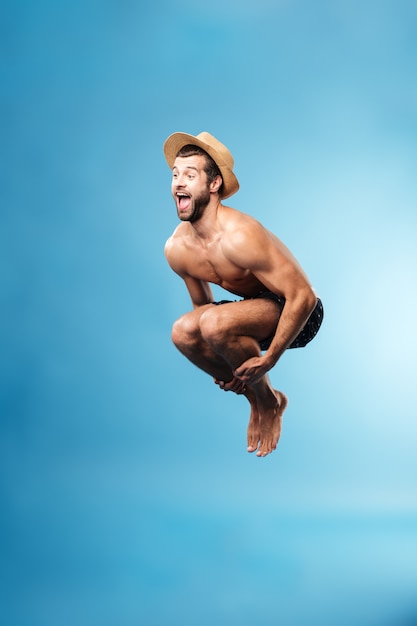 Hombre de salto aislado sobre pared azul