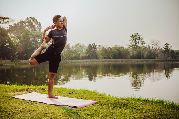 Hombre sano entrenando la flexibilidad en la naturaleza