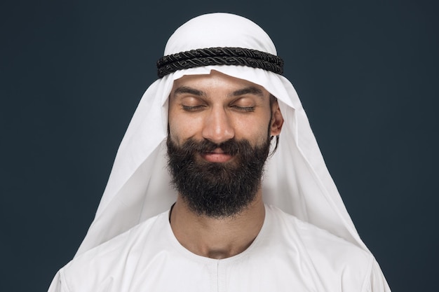 Hombre saudí árabe sobre fondo azul oscuro studio