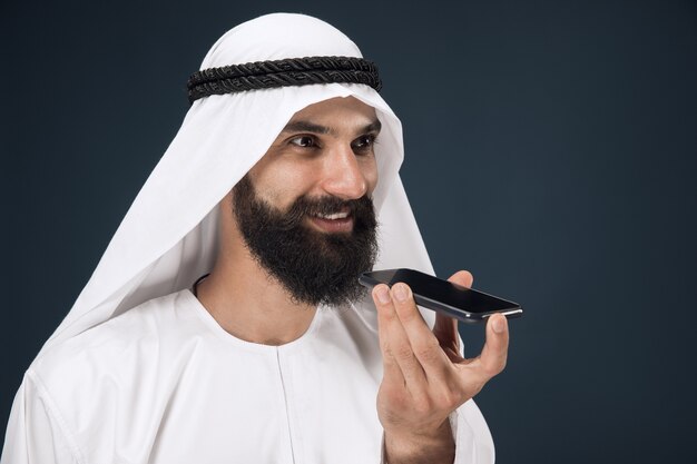 Hombre saudí árabe sobre fondo azul oscuro studio