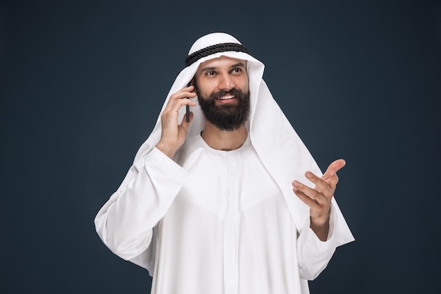 Hombre saudí árabe sobre fondo azul oscuro studio