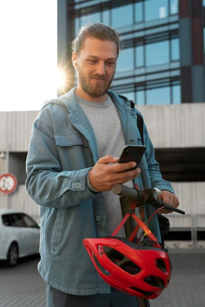 Hombre con scooter mirando su teléfono