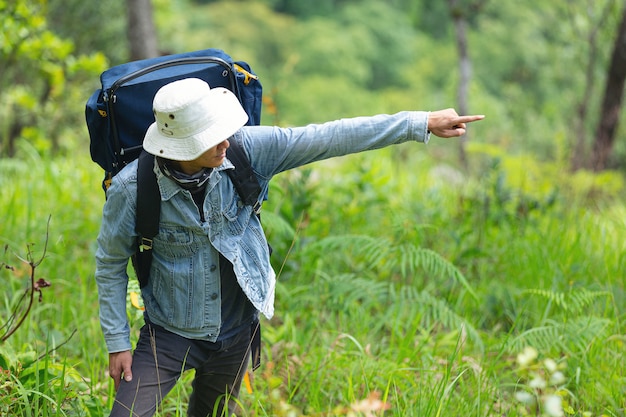 Un hombre de senderismo feliz camina por el bosque con una mochila.