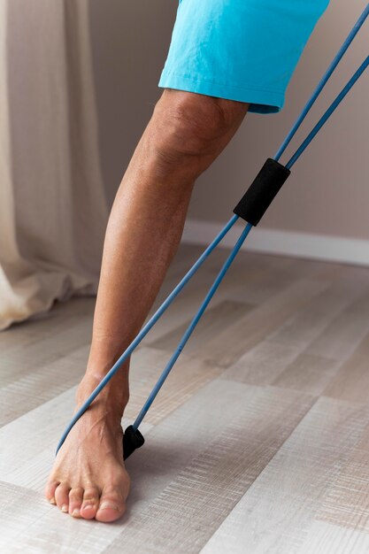 Hombre senior con accesorios de fitness en interiores