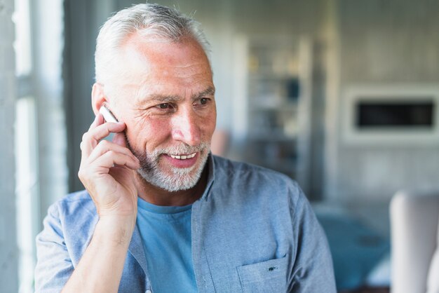 Hombre Senior con auriculares inalámbricos bluetooth