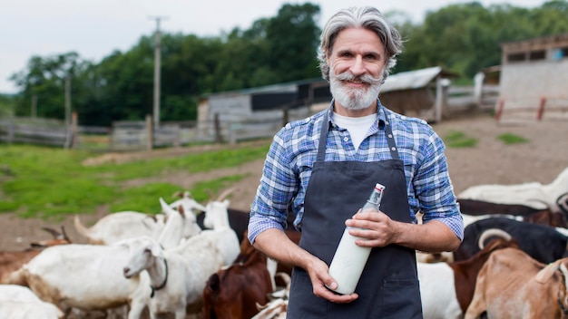 Hombre senior con botella de leche de cabra
