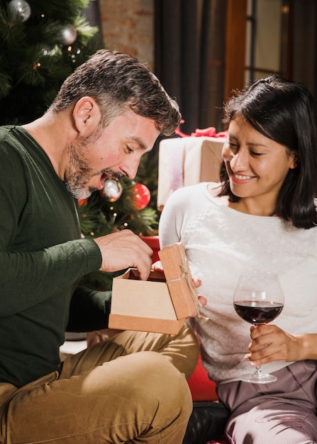 Hombre senior emocionado abriendo su regalo