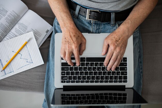 Hombre senior haciendo clases en línea en un portátil.