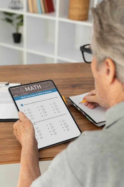 Hombre senior haciendo clases online en una tableta