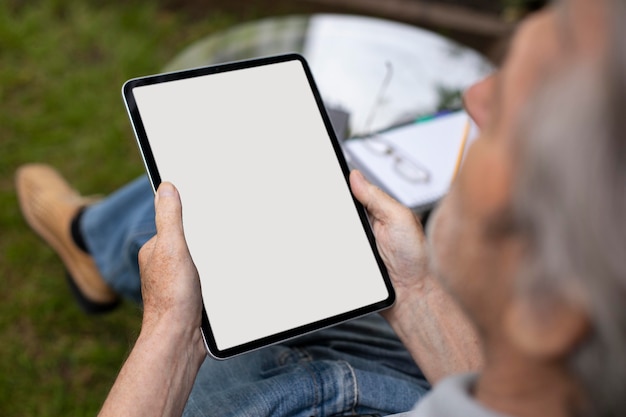 Hombre senior haciendo clases online en una tableta