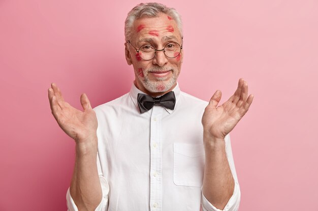 Hombre senior con manchas de lápiz labial en la cara