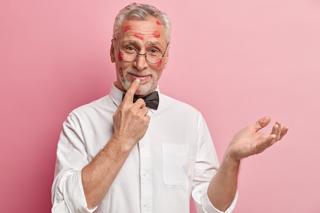 Hombre senior con manchas de lápiz labial en la cara