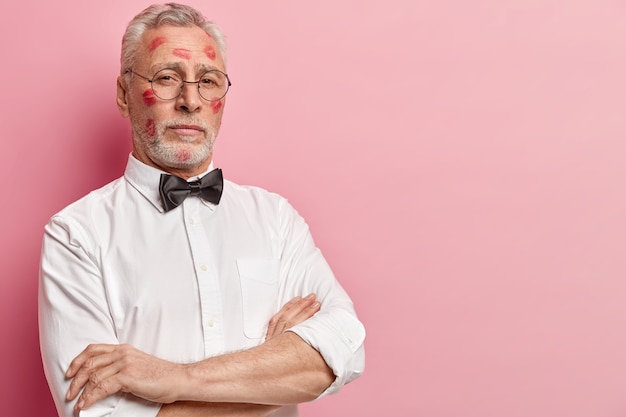 Hombre senior con manchas de lápiz labial en la cara