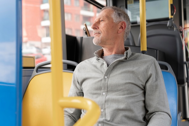 Hombre senior moderno sentado en el autobús