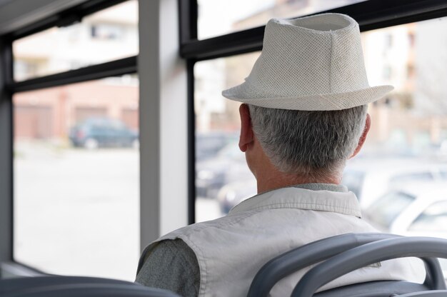 Hombre senior moderno sentado en el autobús