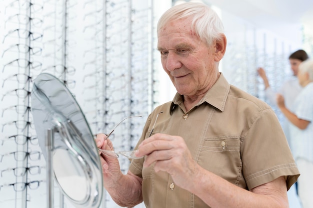 Foto gratuita hombre senior probándose un nuevo par de gafas