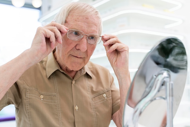 Foto gratuita hombre senior probándose un nuevo par de gafas