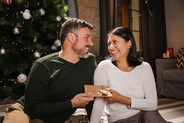 Hombre senior sonriente dando un regalo a su cónyuge