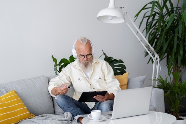 Hombre senior de tiro medio aprendiendo con portátil