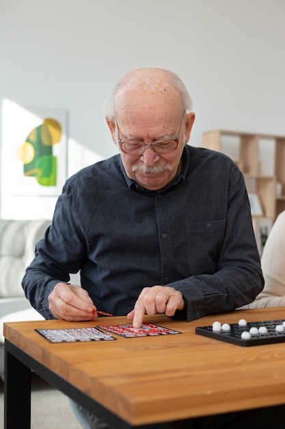 Hombre senior de tiro medio jugando bingo