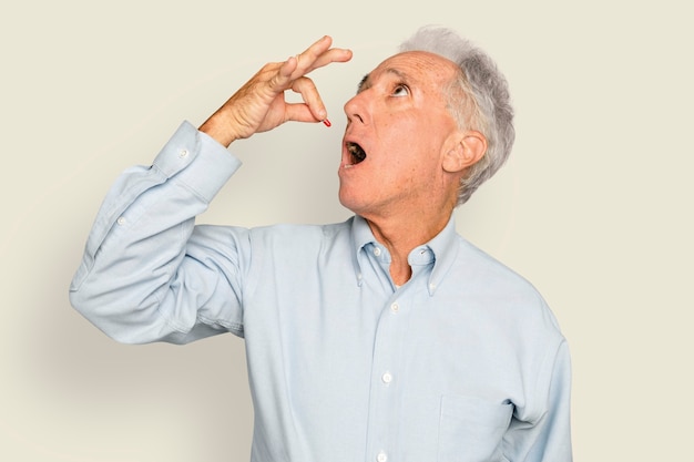 Foto gratuita hombre senior tomando su medicina en cápsula