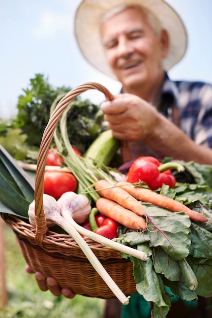 Foto gratuita hombre senior trabajando en el campo con verduras