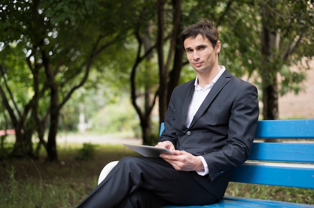 Hombre sentado en un banco azul