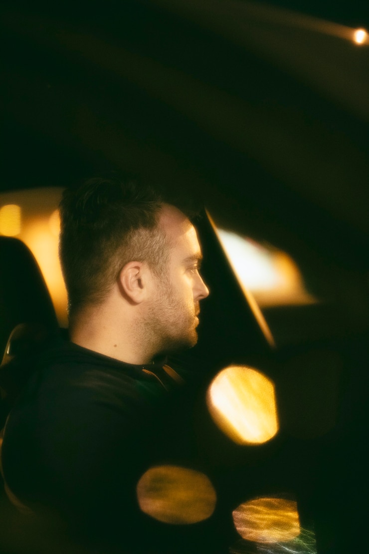 Foto gratuito hombre sentado en el coche por la noche