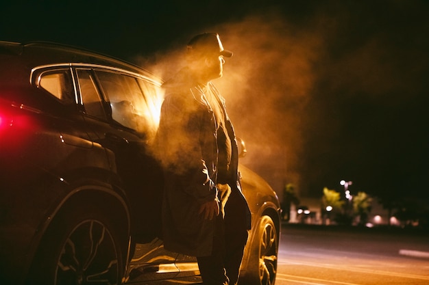 Hombre sentado en el coche por la noche