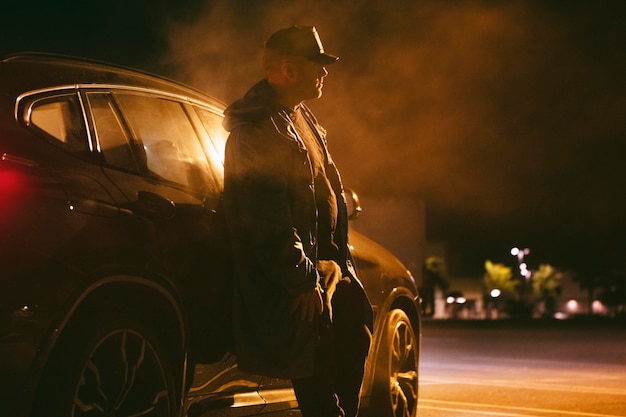 Hombre sentado en el coche por la noche