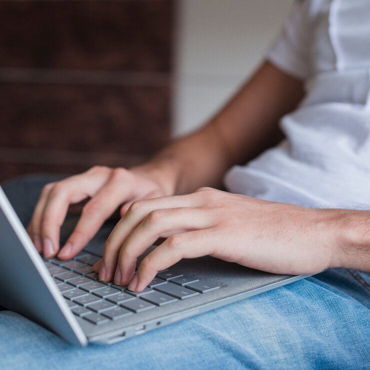 Foto gratuito hombre sentado y escribiendo en la computadora portátil