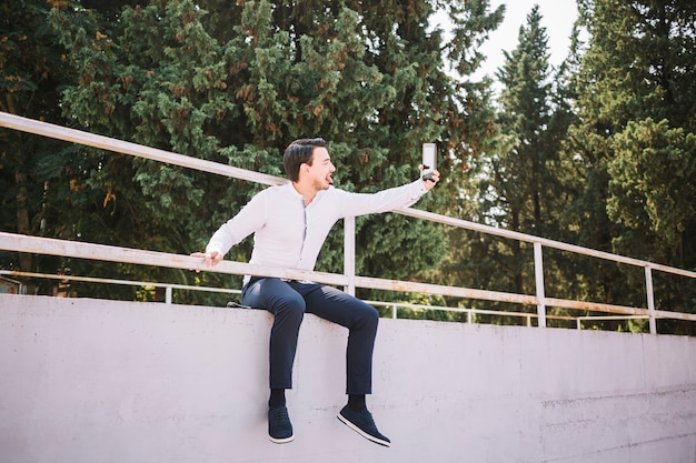Hombre sentado haciéndose un selfie
