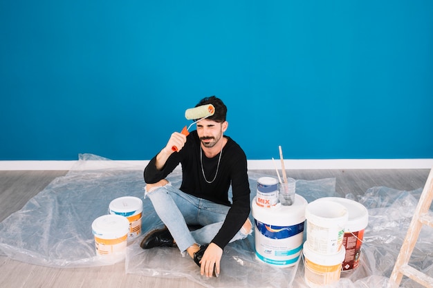 Hombre sentado con materiales de pintura